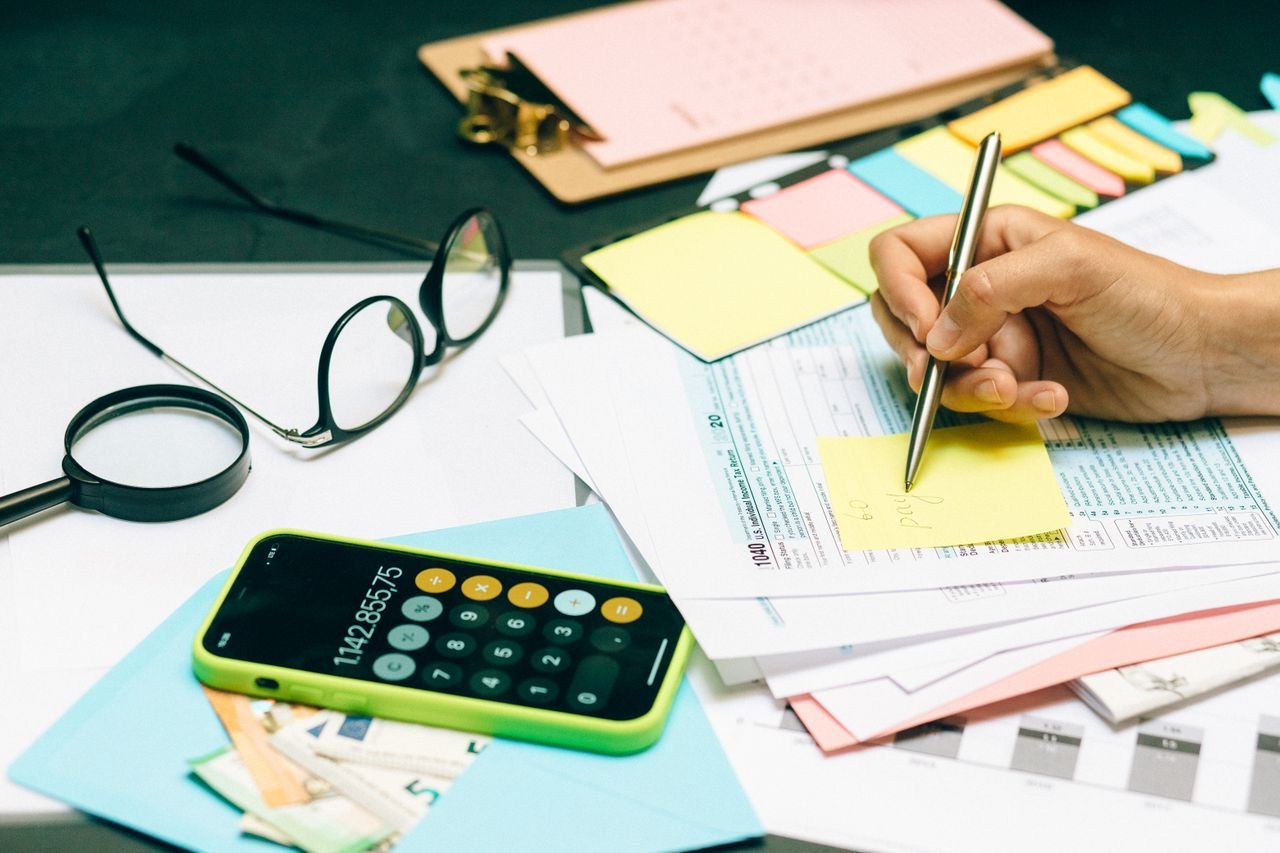 Close-up of an office desk with a calculator, glasses, and documents for financial planning